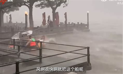 西湖工作人员在暴雨中保护船只